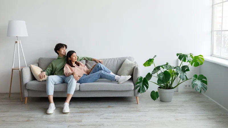 A couple relaxing together on a sofa in a bright living room