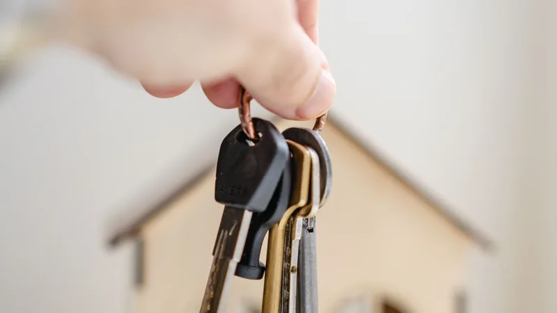 A hand holding keys on a house-shaped keyring